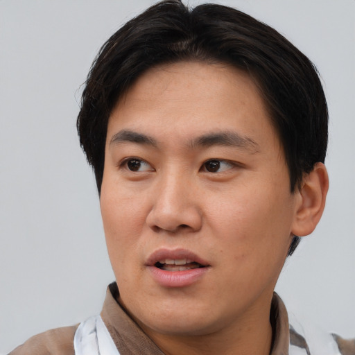 Joyful asian young-adult male with short  brown hair and brown eyes