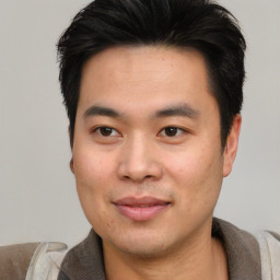 Joyful asian young-adult male with short  black hair and brown eyes