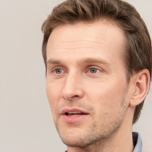 Joyful white adult male with short  brown hair and grey eyes