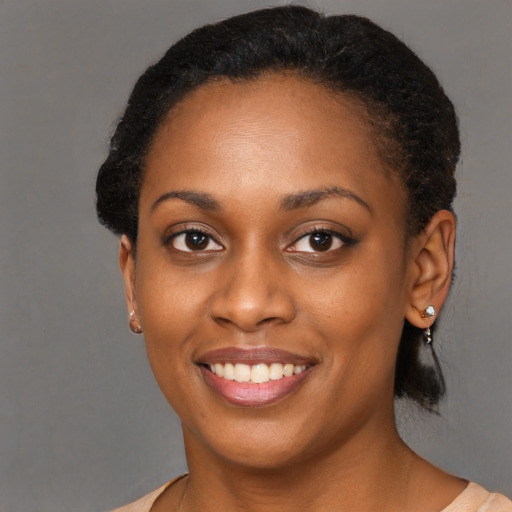 Joyful black young-adult female with short  black hair and brown eyes