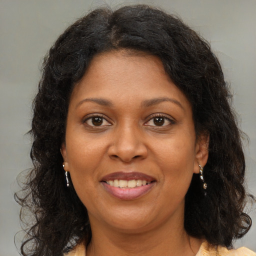 Joyful black adult female with medium  brown hair and brown eyes