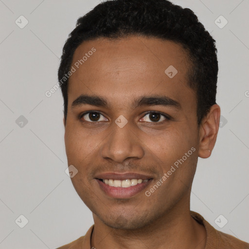 Joyful black young-adult male with short  brown hair and brown eyes