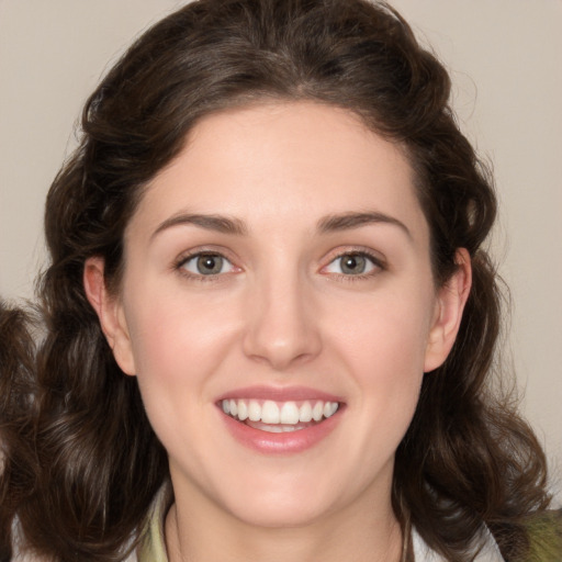 Joyful white young-adult female with medium  brown hair and green eyes