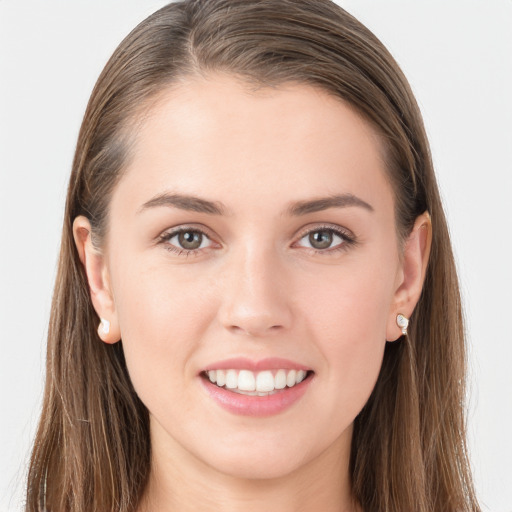 Joyful white young-adult female with long  brown hair and grey eyes