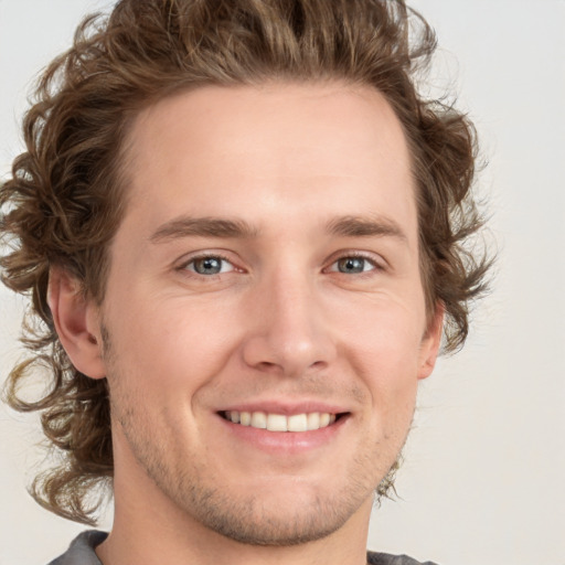 Joyful white young-adult male with medium  brown hair and grey eyes