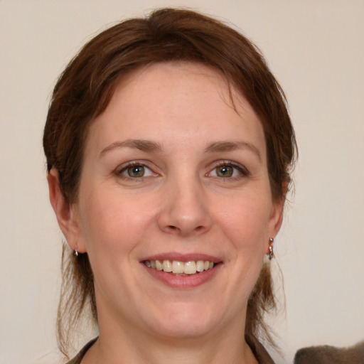 Joyful white young-adult female with medium  brown hair and blue eyes