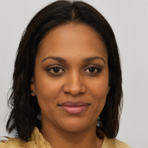 Joyful black young-adult female with medium  brown hair and brown eyes