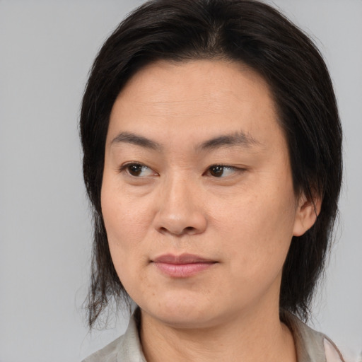 Joyful asian adult female with medium  brown hair and brown eyes