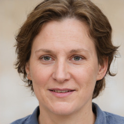 Joyful white adult female with medium  brown hair and blue eyes