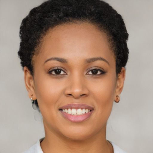 Joyful black young-adult female with short  brown hair and brown eyes