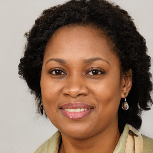 Joyful black adult female with long  brown hair and brown eyes
