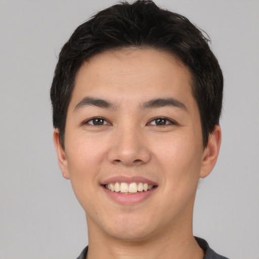 Joyful asian young-adult male with short  brown hair and brown eyes