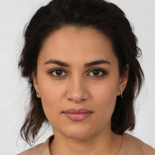 Joyful latino young-adult female with medium  brown hair and brown eyes
