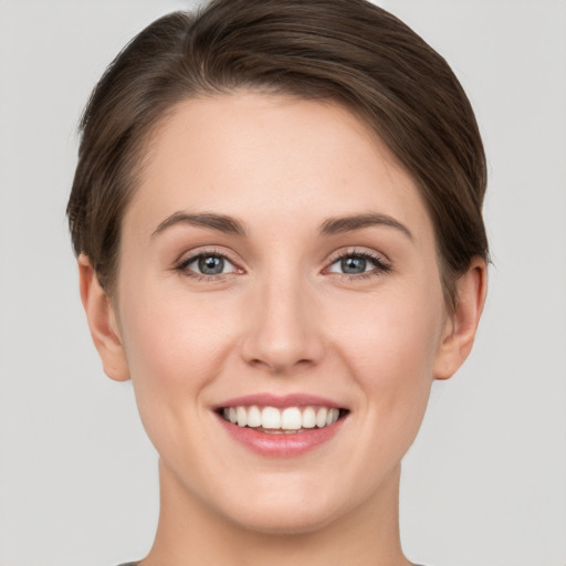 Joyful white young-adult female with short  brown hair and grey eyes