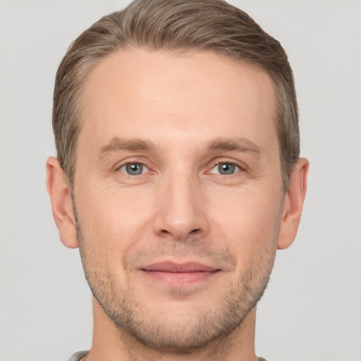 Joyful white adult male with short  brown hair and grey eyes