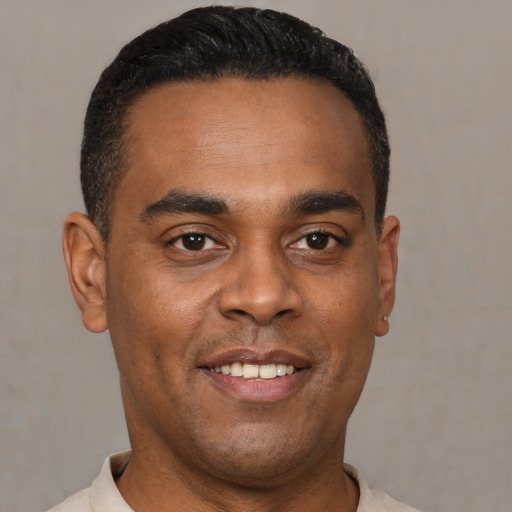 Joyful latino young-adult male with short  black hair and brown eyes