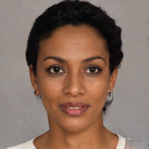 Joyful black young-adult female with short  black hair and brown eyes