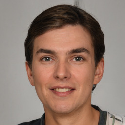 Joyful white young-adult male with short  brown hair and grey eyes