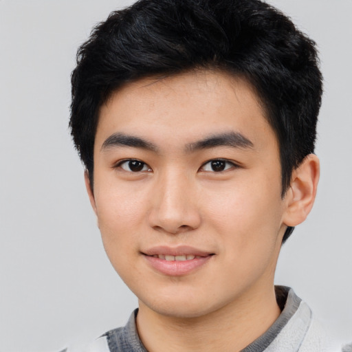 Joyful asian young-adult male with short  black hair and brown eyes