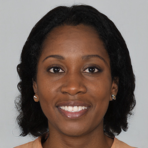 Joyful black young-adult female with medium  black hair and brown eyes