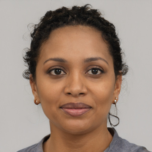 Joyful black young-adult female with short  black hair and brown eyes