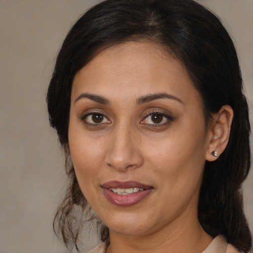 Joyful latino adult female with medium  brown hair and brown eyes