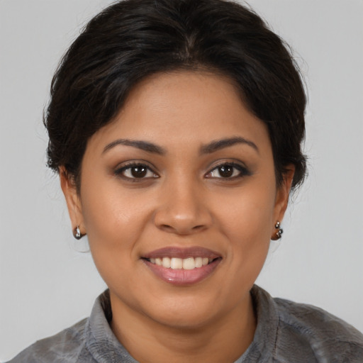Joyful latino young-adult female with medium  brown hair and brown eyes