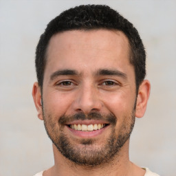 Joyful white young-adult male with short  black hair and brown eyes