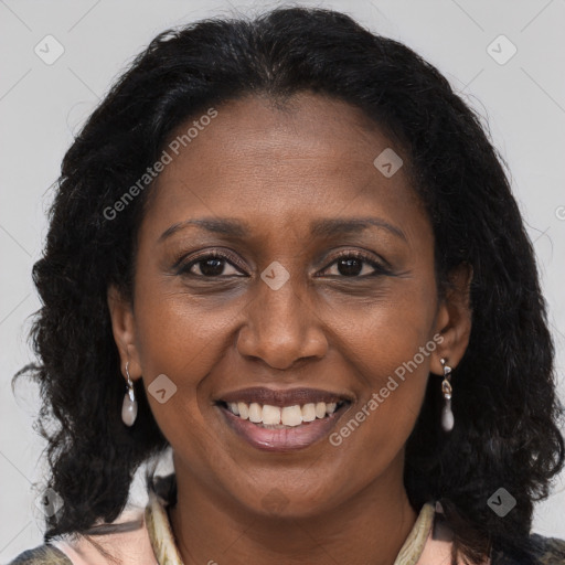 Joyful black adult female with long  brown hair and brown eyes