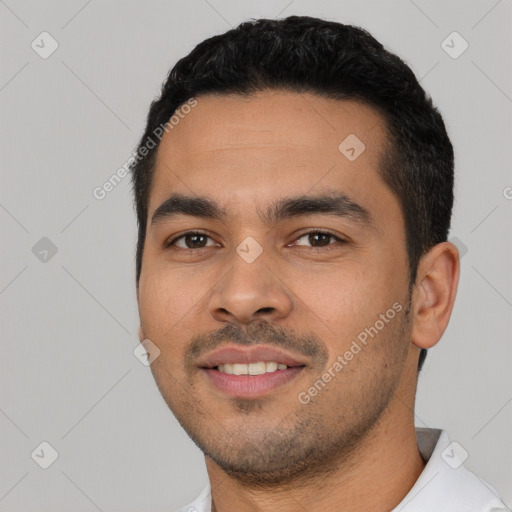 Joyful latino young-adult male with short  black hair and brown eyes