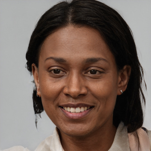 Joyful black adult female with medium  brown hair and brown eyes
