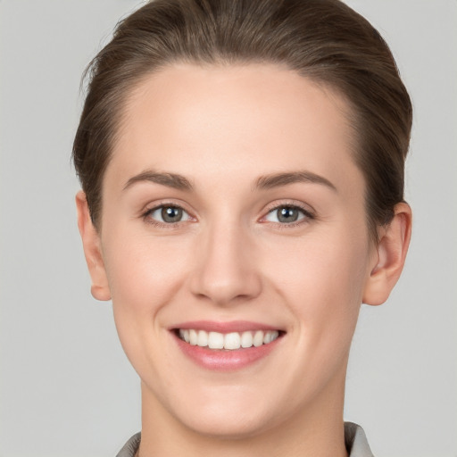 Joyful white young-adult female with short  brown hair and grey eyes