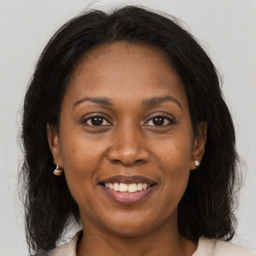 Joyful black adult female with long  brown hair and brown eyes