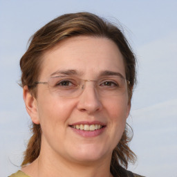 Joyful white adult female with medium  brown hair and blue eyes