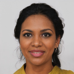 Joyful black young-adult female with long  brown hair and brown eyes