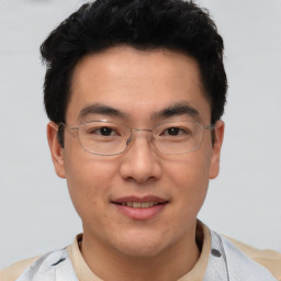 Joyful asian adult male with short  brown hair and brown eyes