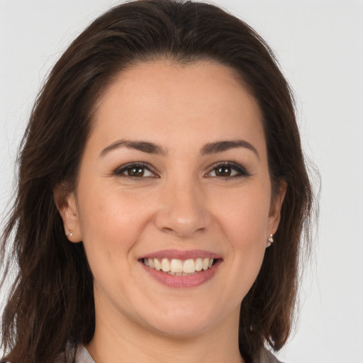 Joyful white young-adult female with long  brown hair and brown eyes