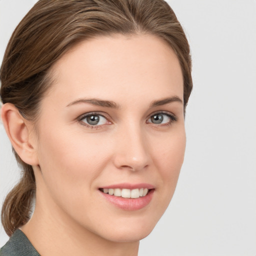 Joyful white young-adult female with medium  brown hair and grey eyes