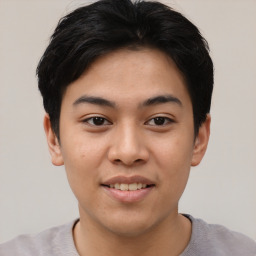 Joyful asian young-adult male with short  black hair and brown eyes