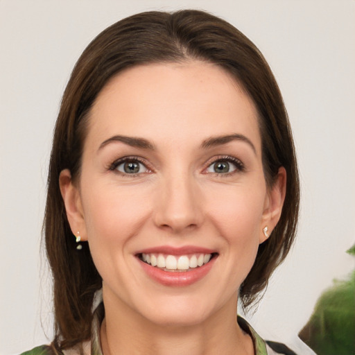 Joyful white young-adult female with medium  brown hair and green eyes