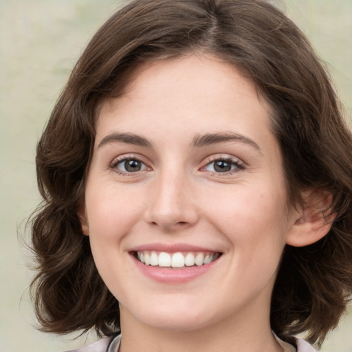 Joyful white young-adult female with medium  brown hair and green eyes