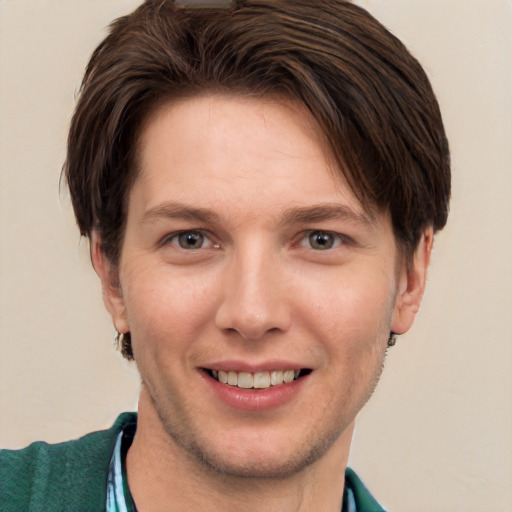 Joyful white young-adult male with short  brown hair and grey eyes