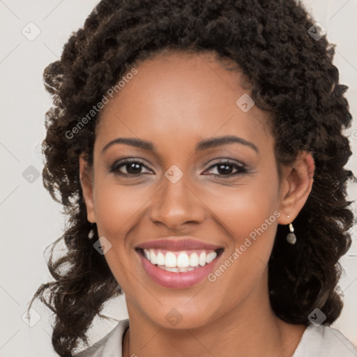 Joyful black young-adult female with long  brown hair and brown eyes