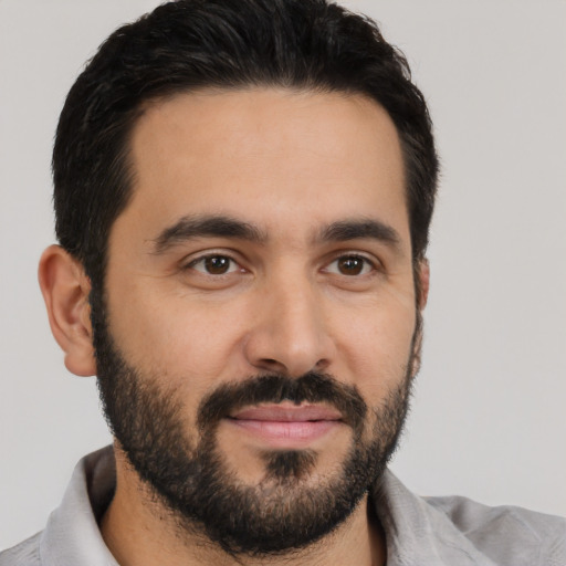 Joyful latino young-adult male with short  black hair and brown eyes