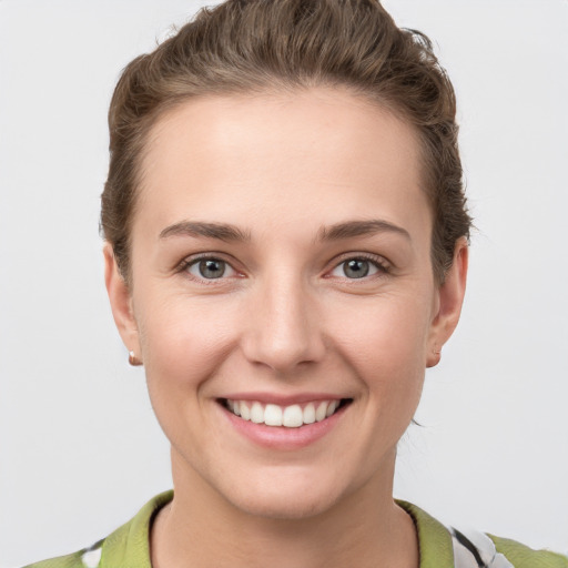 Joyful white young-adult female with short  brown hair and grey eyes