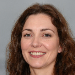 Joyful white adult female with long  brown hair and brown eyes