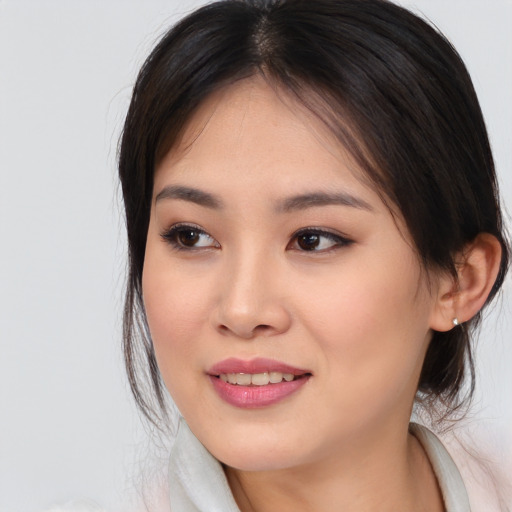 Joyful asian young-adult female with medium  brown hair and brown eyes