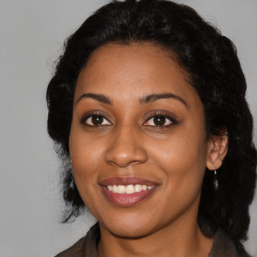 Joyful black young-adult female with long  black hair and brown eyes