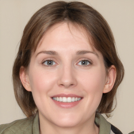 Joyful white young-adult female with medium  brown hair and grey eyes