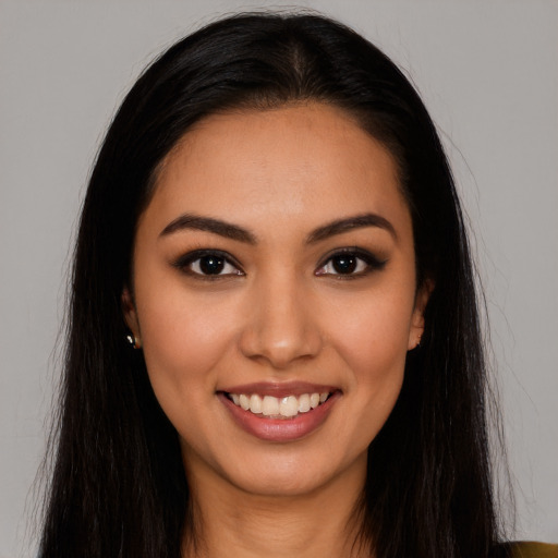 Joyful latino young-adult female with long  brown hair and brown eyes